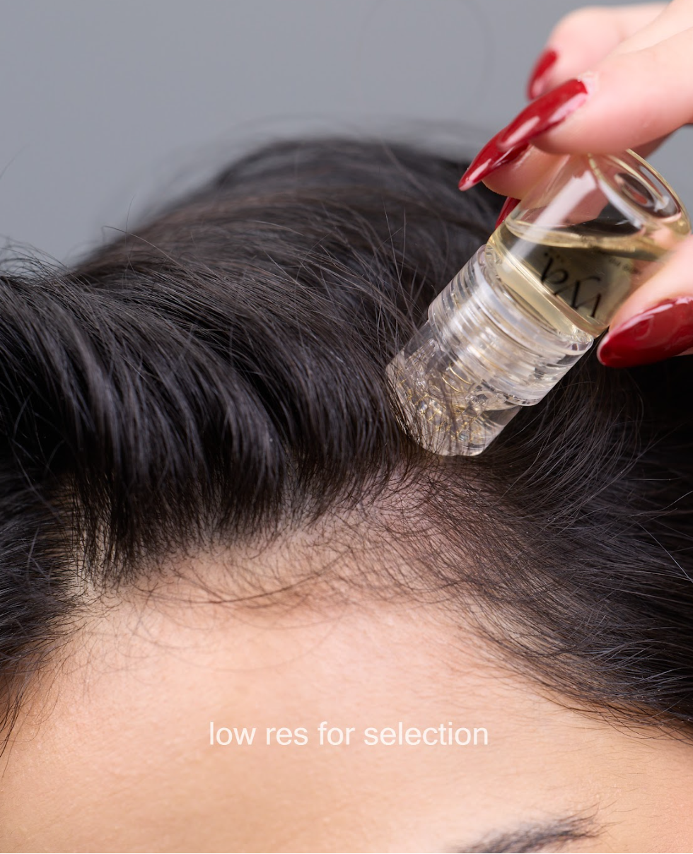 applying hair growth treatment using micro infusion tool directly onto the scalp